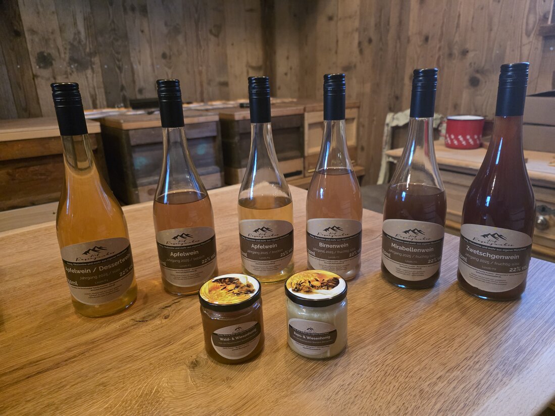 Flaschen mit Obstwein auf Holztisch